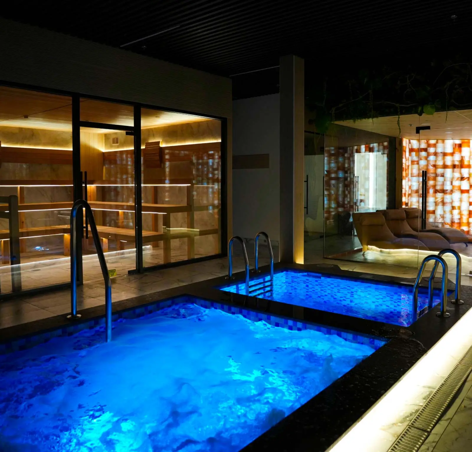 Indoor hydrotherapy circuit with hot soak and cold plunge pools for contrast therapy at Fusion Spa & Resort.