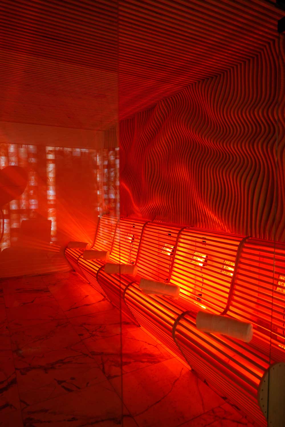 Infrared sauna room with red light therapy glow for deep relaxation at Fusion Spa & Resort.